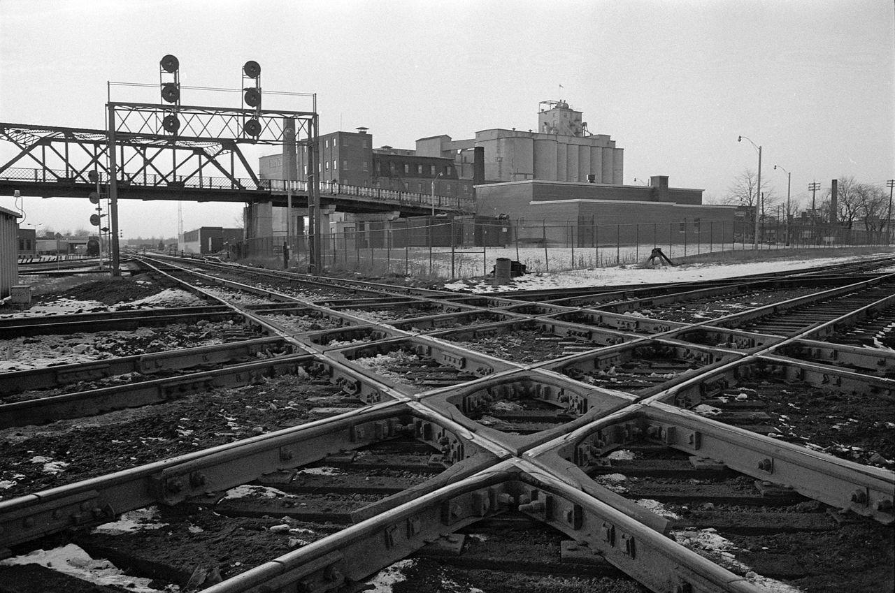 The West Toronto Diamond in January 1975, the junction of CP's Galt, Mactier and North Toronto subs, and CN's Brampton sub.  To the left was the CPR West Toronto station, to the right was CN's West Toronto Station.  The tracks heading under the signal bridge lead to Lambton Yard, on the other side of the Old Weston Road bridge.  And behind the photographer was CP's service track, formerly the Toronto, Grey and Bruce mainline.

Pretty much everything in this photo is gone now, the Old Weston Road bridge was closed to road traffic in 1972 and demolished in 1981.  It was one of the best vantage points in Toronto to watch trains. 

The diamond was taken out of service May 23, 2014, after 130 years of service, when the grade separation for the Union Pearson Express was competed