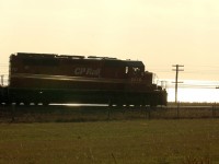 The late autumn sun reflects off Lake Ontario backlighting a westbound CP Rail freight led by an SD40.