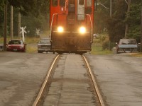 With bell ringing and lights on, Trillium 108 heads up Townline Road in Thorold with three boxcars for Interlake Paper.  The Townline spur hasn't seen service since a trestle down the hill was vandalized in 2007.