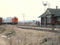 A lot can be said about this image........so...........The trash. Disgusting, but what can you do? Some of us on this group can recall days when trying to photograph stopped trains (or even moving ones!) and just as the shutter clicked, someone on board was throwing garbage out the window. It was almost an epidemic. Metal water cans (10 oz) were the worst. Then it became plastic water bottles. And everything else. This image is an example of that. Wind from the NW has blown collective trash into the ditch.  There are work cars on the North siding by the old Winona station as the CN Budds, Toronto-bound, slow to pick up passengers. One has to wonder if anyone used that classic outhouse in the photo, other than maintenance crews. There were times when I used to see them everywhere along the railways.  They're all gone, and they're certainly not in the hands of collectors of rail artifacts. :o) Probably torched.
Winona station burned down in the fall of 1975. It was located just to the east of Winona Rd; and west of this crossing fruit storage building(s) stood and sidings were usually occupied by cars left in order the locals could fill them with baskets of various crops to rush to the Toronto market. It was once very busy along the line in Niagara, with fruit storage buildings at every community. Naturally, this traffic was eventually lost to trucking, and the daily seasonal local ceased to exist.