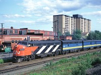 CN FP9A 6532 leads train #11, the Scotian, through Southwestern Jct. The Fairview roundhouse is in the background.