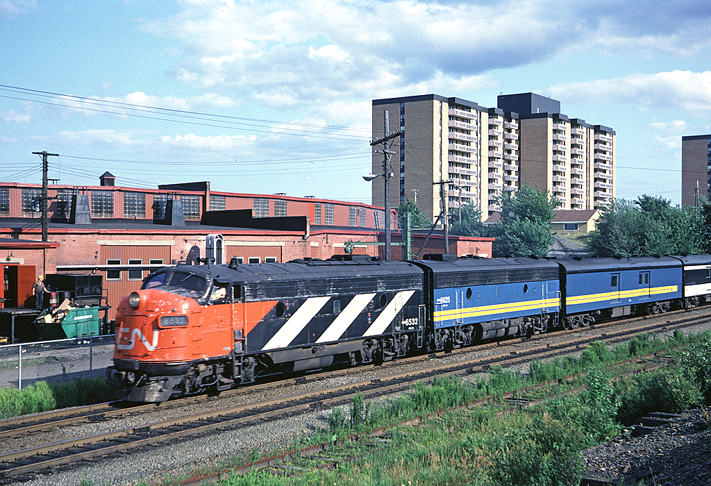 CN FP9A 6532 leads train #11, the Scotian, through Southwestern Jct. The Fairview roundhouse is in the background.
