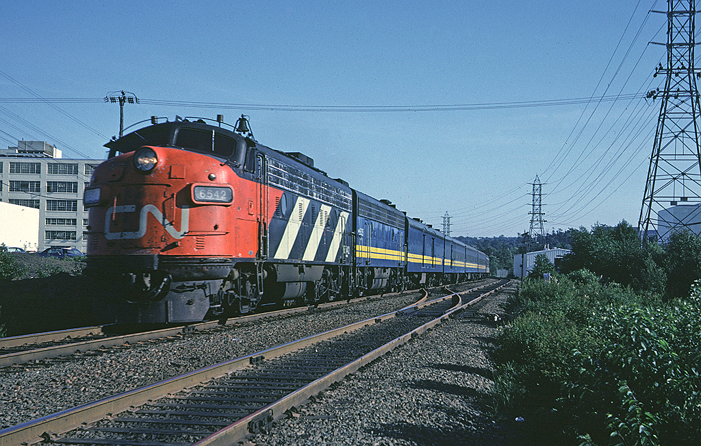 CN FP9A 6542 is leading train #11 "Scotian" a few miles out of Ocean Terminal enroute to Montreal, passing the Simpson-Sears building in Halifax.