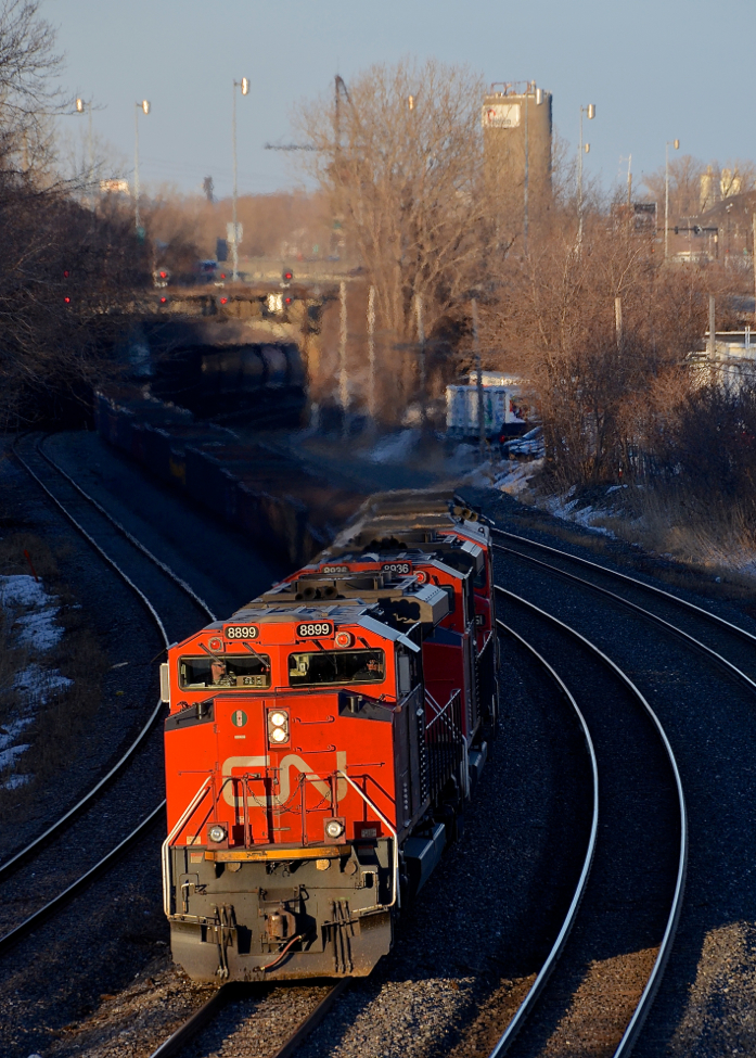 Darkness and light. As Montreal West is built on on an escarpment, it can get shadowy at track level on CN's Montreal sub well before the sun sets. Here the nose of CN 8899 is the only thing well lit at track level as CN X321 heads west about 45 minutes before sunset earlier this evening. The lashup is 4 GMD units (CN 8899, CN 8936, CN 5551 & CN 4724).