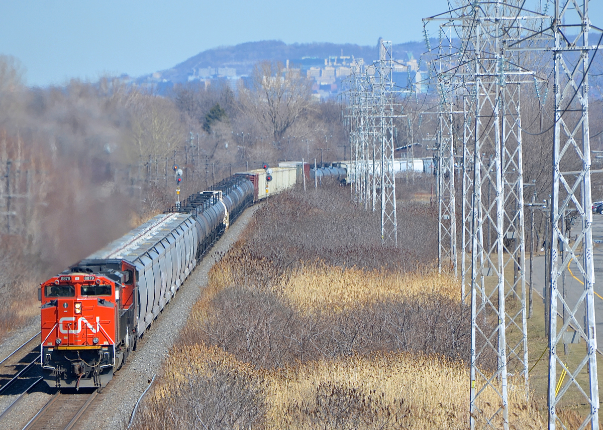 CN 8879 & CN 2673 lead CN 377 around a curve on CN's Kingston Sub in Pointe-Claire on a sunny and warm afternoon.