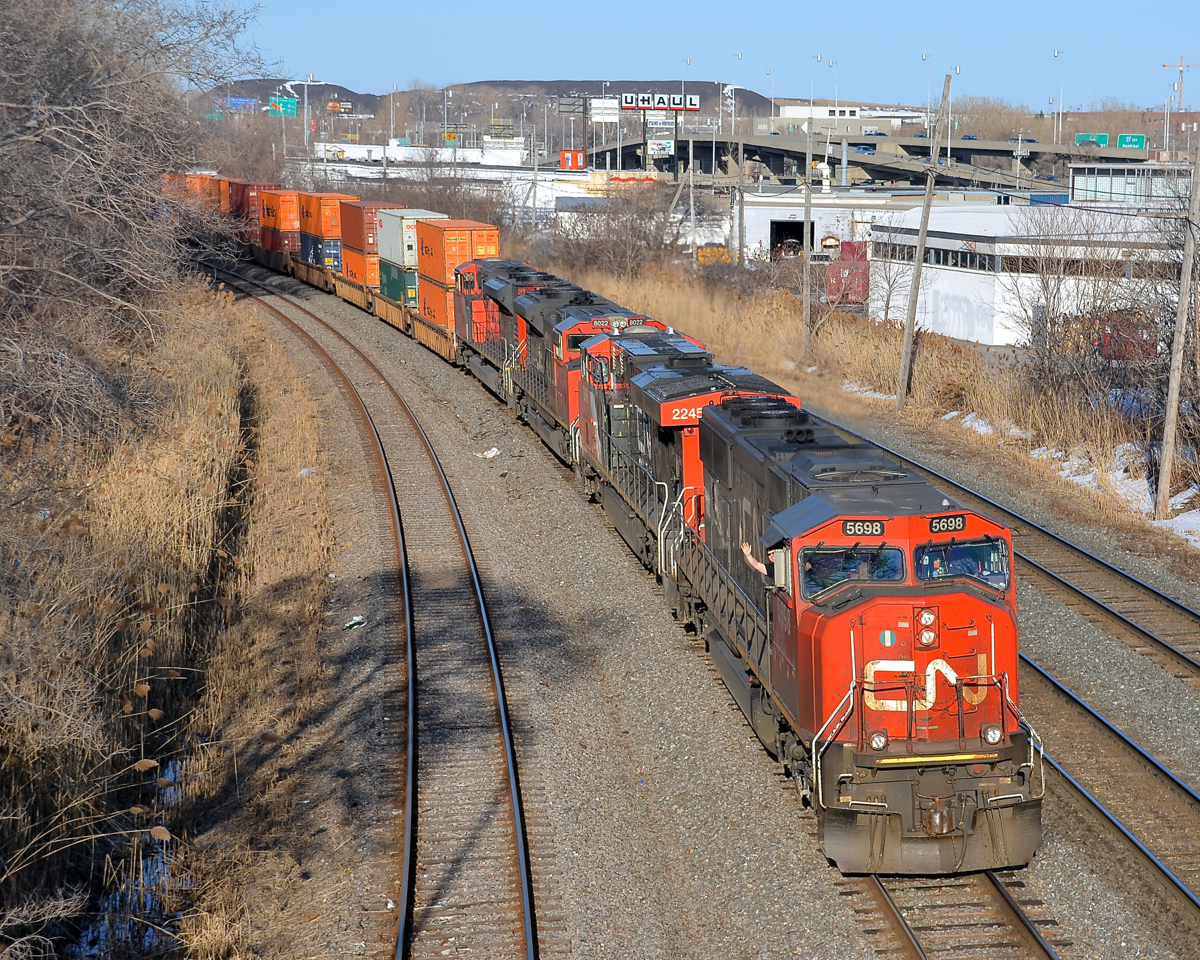 While CN 401 (Joffre Yard to Taschereau Yard) has autoracks at the head end 99% of the time, today it had intermodal, followed by a string of loaded TankTrain cars. It has 4 units (CN 5698, CN 2245, CN 8022 and another SD70M02) as engineer Mathieu Gosselin waves from the lead unit. The train is passing through Montreal West and is nearly at Taschereau Yard.