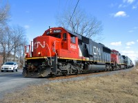 CN 323 has CN 5484 and CN 2515 as it prepares to cross Chemin des Prairies in suburuban Brossard, on its way back from St. Albans, Vermont and interchange with the NECR. Close behind is CN 522.