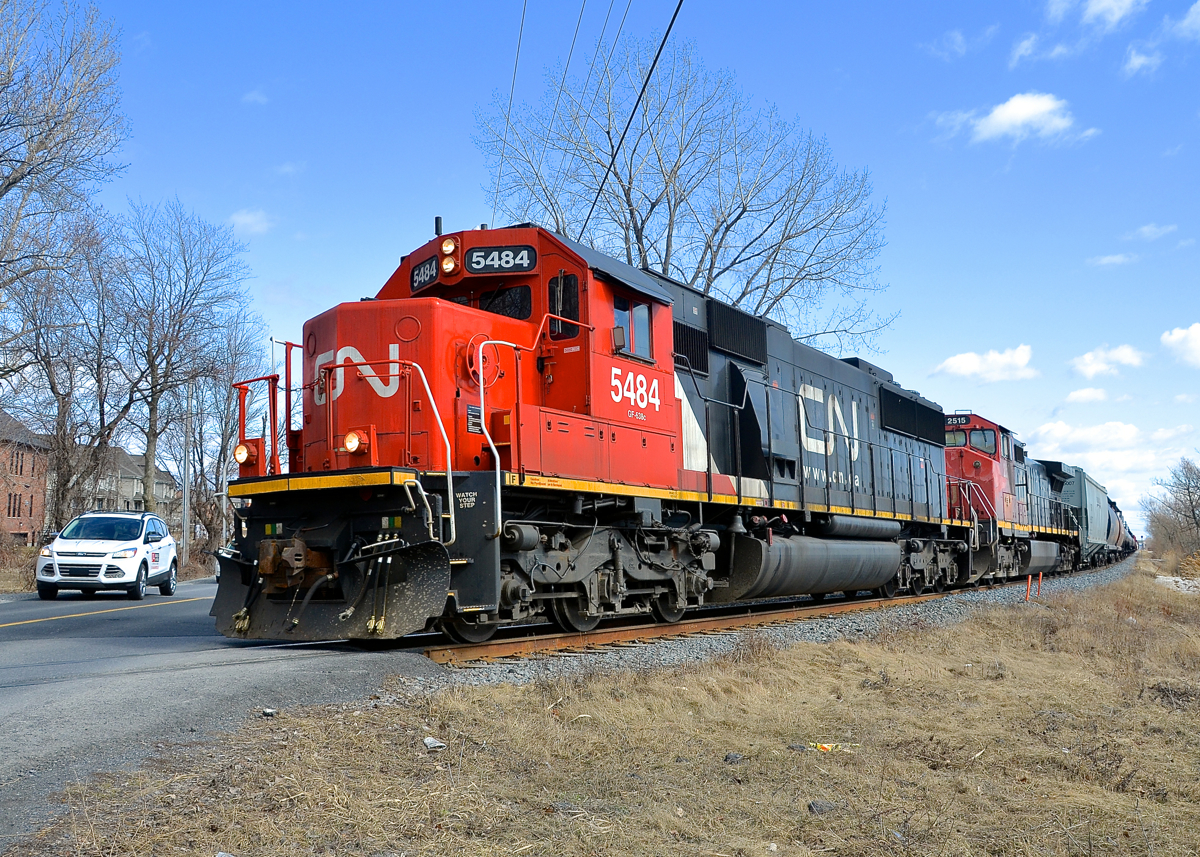 CN 323 has CN 5484 and CN 2515 as it prepares to cross Chemin des Prairies in suburuban Brossard, on its way back from St. Albans, Vermont and interchange with the NECR. Close behind is CN 522.