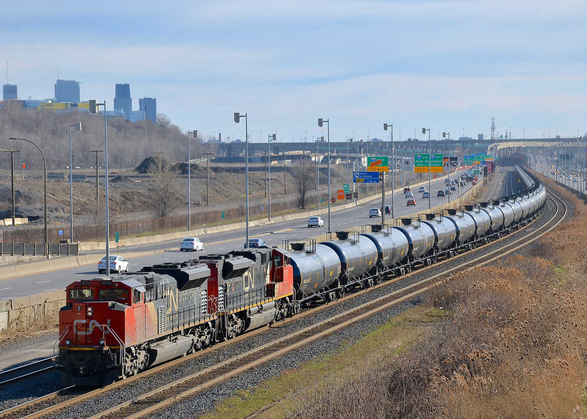 A pair of SD70M-2's (CN 8849 & CN 8812) lead CN 705 towards a crew change at Turcot West. Downtown Montreal is visible in the background at left.
