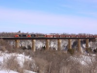 Three CN locomotives lead this westbound freight train across the single-tracked trestle in Georgetown.  This span has since been double-tracked and the piers have been widened to be able to support three tracks, part of the upgrades for future transit expansion. 