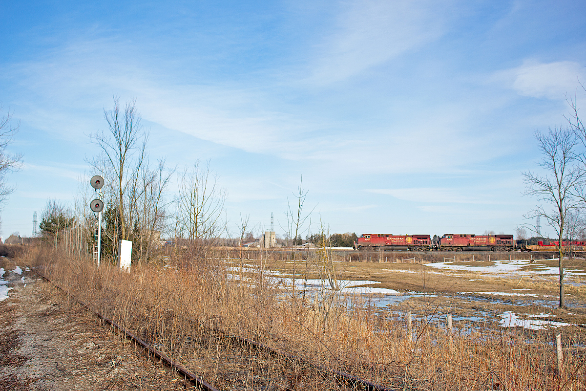 After meeting CP 550 at Baxter, 119 chugs uphill through Utopia with double stacks in tow. Like usual, there is no DPU for this Edmonton bound stacker. Here, it crosses the now abandoned section of the BCRY Meaford Spur. Shortly before abandonment in 2011, a One Way Low Speed (OWLS) diamond was installed to reduce maintenance. However, only a few months later, the line was abandoned, and the diamond has since been mostly dismantled. The signals, however remain turned on, and I guess they will display solid red until the bulbs fade out. The Meaford, built in 1855, is one of the oldest rail lines in Canada, and is a half a century older than the MacTier. Evidently though, the MacTier has had much greater success, being a transcon route. It would be a pity to see the Utopia-Collingwood section of the Meaford torn up, however rail trails seem to be the way of the future. Personally, I'd love to see the BCRY operate a Barrie-Collingwood heritage train, much like sister railroad OBRY does. Only time will tell though.