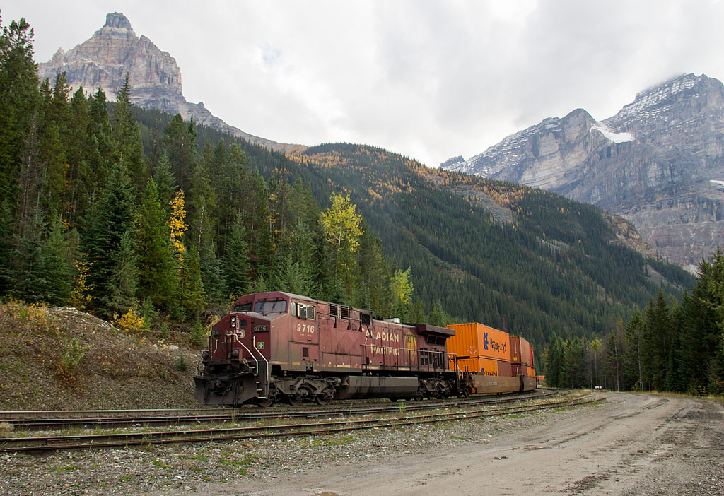 Cathedral Mountain and Mount Stephen are framed on either side of CP 198, which is climbing the Big Hill. CP 9716, looking rubby with coal dust, shoves as tail end remote, as CP 8944 and CP 8712 pull up front.