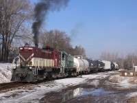On a wet day in March, two S-13 locomotives shuffle cars around in the yard at Tillsonburg.