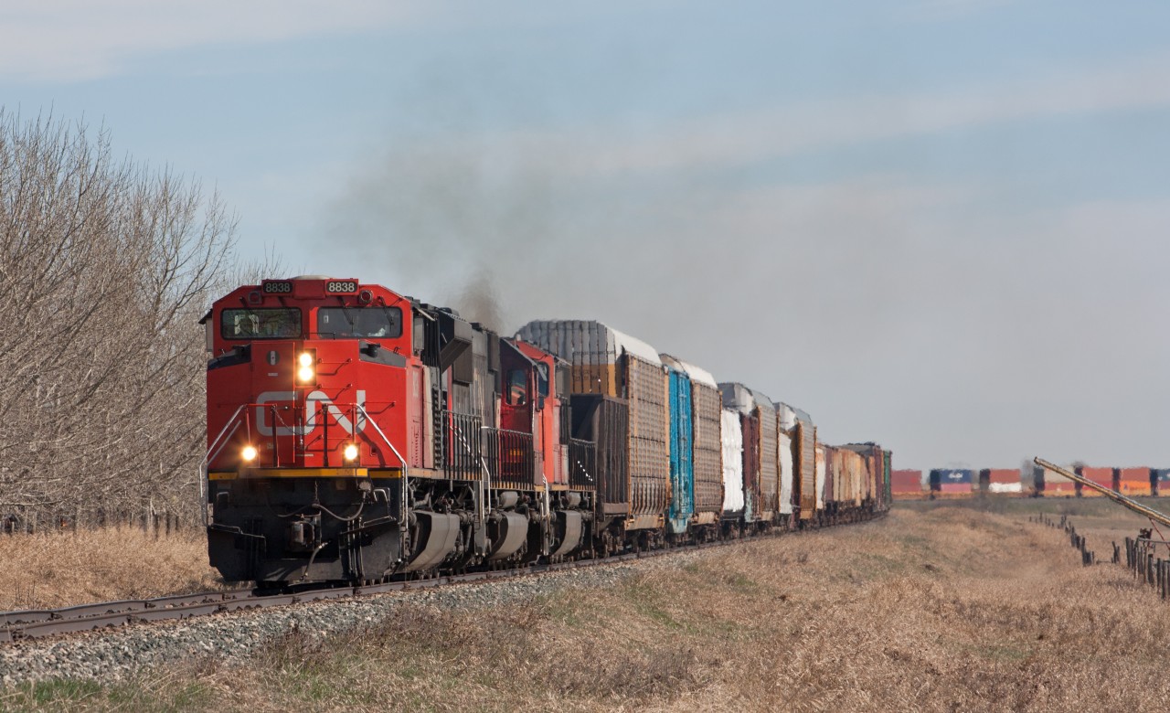 Busy day on the CN Three Hills Sub. CN 442 southbound, hot on the heels of CN 115 that just went by a few minutes prior.  A lot of maintenance equipment parked along sidings, and a ballast train was ready to head north once 115 and 442 cleared the main.