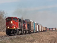 Busy day on the CN Three Hills Sub. CN 442 southbound, hot on the heels of CN 115 that just went by a few minutes prior.  A lot of maintenance equipment parked along sidings, and a ballast train was ready to head north once 115 and 442 cleared the main. 