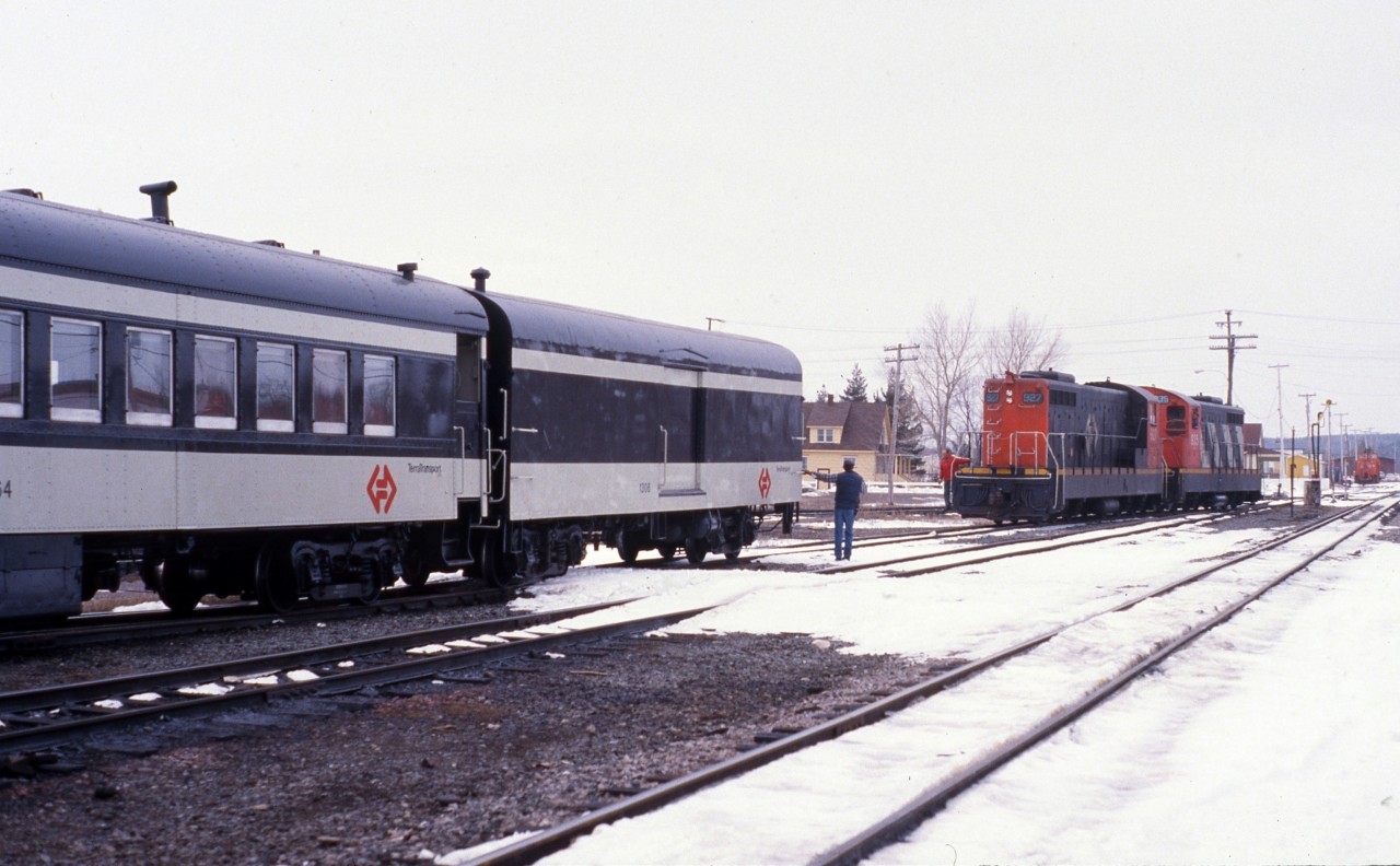 Trainman Gerald Turner prepares to couple Terra Transport baggage car 1308 and coach 764 to NF210's 927 and 935 just prior to the departure of Mixed Extra 935 West at Bishops Falls, Newfoundland on April 16, 1988. Formerly known as Train # 203, this mixed train with a passenger only consist would travel 138 miles to the city of Corner Brook by crossing the Gaff Topsails, the highest point of the railway on the entire Island at 1550 feet above sea level. The only passengers to travel the entire route that day were the photographer and his friend Paul, one other, a cabin owner who had gotten on Millertown Junction would depart at Gaff Topsail. This scene was on borrowed time as just a few months later on September 30, this train and all other rail service in Newfoundland would be shut down for good and the rails removed. Images such as these can be seen in my two books, RAILS ACROSS THE ROCK and it's sequel, RAILS AROUND THE ROCK, published by Creative Book Publishing of St. John's.