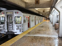 It's a rainy day in the city as a set of Bombardier T1 subway cars pause at the Toronto Transit Commission's Eglinton West subway station on the trip south on the Spadina Line. It's even wet in the subway - water pools on the north side of the platforms, probably blown or leaking in from the open section just behind us. Cars from the nearby Allen Expressway (on either side of the subway line) can be heard swishing past on rainy pavement...well, at least on the northbound side; the southbound traffic is perpetually choked at the Eglinton Avenue West exit.
<br><br>
To add a little spice to the system compared to its previous utilitarian and functional stations (that some compare to public washrooms because of the spartan nature and tiling), in the 1970's the TTC approached a number of architectural firms to design stations along the new Spadina subway line, which opened in 1978. Eglinton West was designed by Arthur Erickson Architects and featured the a mix of concrete, brick, dark earth tones, sharp edges and windows lining the platforms, heralding the transition from bright outdoor open cut subway line to subterranean underground tunnels south of Eglinton. Art installations were also featured at each station, and Eglinton West is known for its large "Summertime Streetcar" mural work by Gerald Zeldin at the south end of the platforms.
