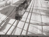 On a sunny January day, we are looking east from the former NS&T bridge over the CN Grimsby sub, as a Hamilton bound freight passes. The train has just passed under the old Merritt Street bridge.  The rail bridge carried the Trillium Rail Town Line Spur, now out of service, the span has been removed.