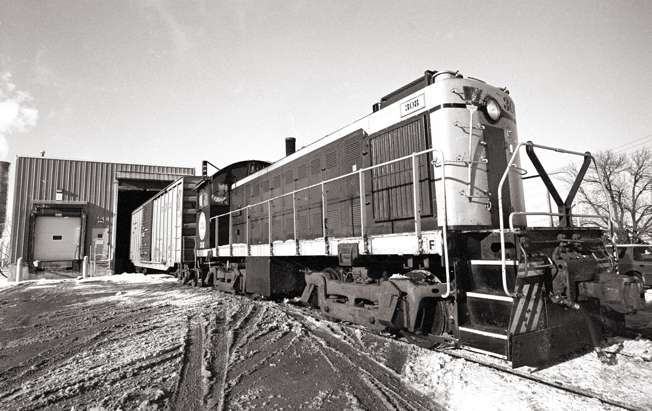 Port Colborne Harbour Railway 308, an Alco S-1, shoves a boxcar into the loading dock of the Interlake Paper plant in Thorold.  This was the last industry left on the Town Line Spur, rail service ended in 2007 after a bridge was damaged by arson.
