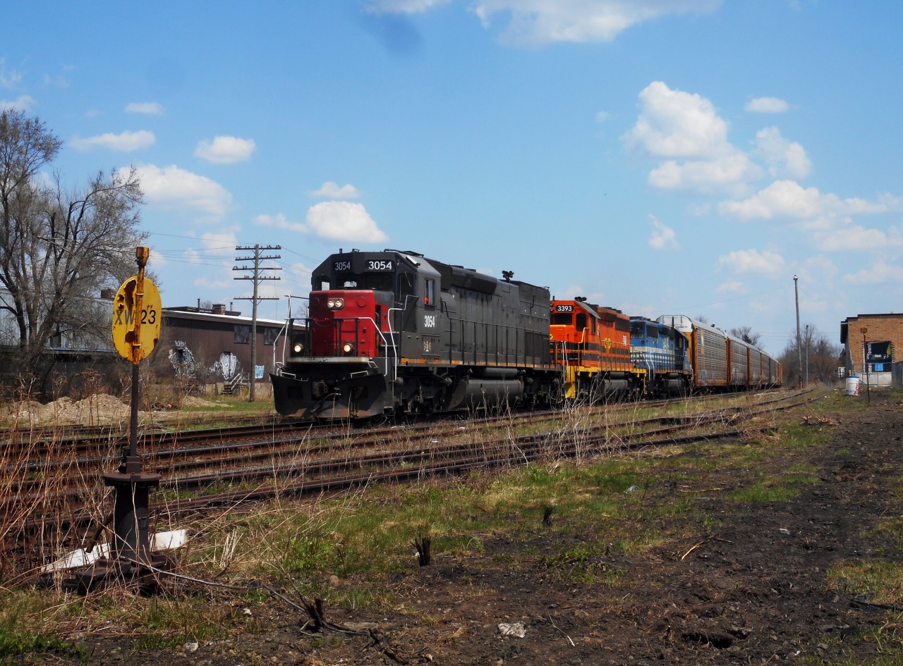 GEXR 3054, 3393, and 7369 roll west through Guelph with 55 cars on a beautiful spring day.