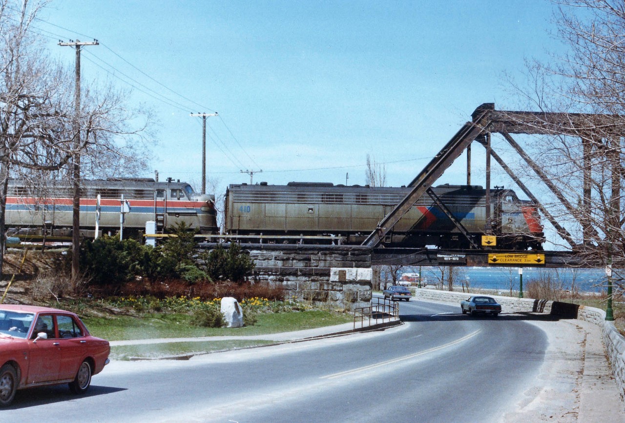 The Amtrak thru Southern Ontario from Windsor thru Fort Erie was really on borrowed time when this image was taken. Grubby old E units and shoddy coaches pretty well summed up this train. By early 1979 the train was re-routed up thru Niagara Falls stateside; and not long after that, well, it was history. I tried a few times to catch this thing, but it was hit and miss due to erratic schedules, as it was prone to breakdowns (2 units, 5 coaches!)on a regular basis. Lighting was tricky; this train I elected to shoot looking northward as it headed to the USA over the Niagara River Parkway after a quick station-stop at the old Flat Roofed Bridgeburg station (now gone)as there just isn't much of a good angle at this late afternoon time of day. My notes are lost, regrettably I do not have record of the second unit number. Interesting though, two paint schemes.