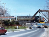 The Amtrak thru Southern Ontario from Windsor thru Fort Erie was really on borrowed time when this image was taken. Grubby old E units and shoddy coaches pretty well summed up this train. By early 1979 the train was re-routed up thru Niagara Falls stateside; and not long after that, well, it was history. I tried a few times to catch this thing, but it was hit and miss due to erratic schedules, as it was prone to breakdowns (2 units, 5 coaches!)on a regular basis. Lighting was tricky; this train I elected to shoot looking northward as it headed to the USA over the Niagara River Parkway after a quick station-stop at the old Flat Roofed Bridgeburg station (now gone)as there just isn't much of a good angle at this late afternoon time of day. My notes are lost, regrettably I do not have record of the second unit number. Interesting though, two paint schemes.