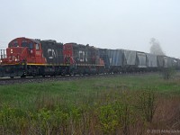 Looming out of the fog, CN 4018 and 7069 lead 516's 56 cars up the grade to Newtonville through Lovekin (yeah ok, Newcastle). The fog and an accompanying chill in the air, rolled in rather suddenly off Lake Ontario, and yielded a few interesting shots of this guy working east to Belleville. Not sure how many of the 4000 series GP9RM's are still working on CN, but I know there aren't too many left. 1729hrs.