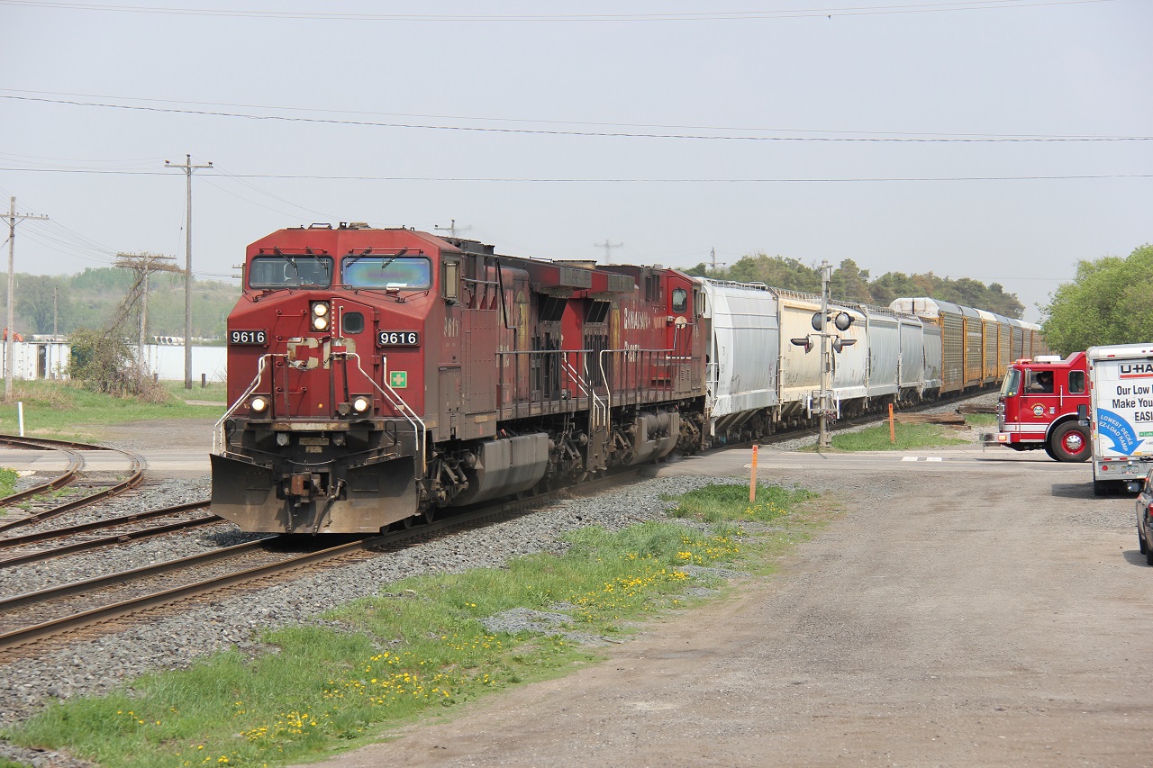 CP 255 is arriving at Wolverton to do work. Here we see it easing through the town of Ayr as a firetruck waits (the sirens were on) on this humid day in May 2015.