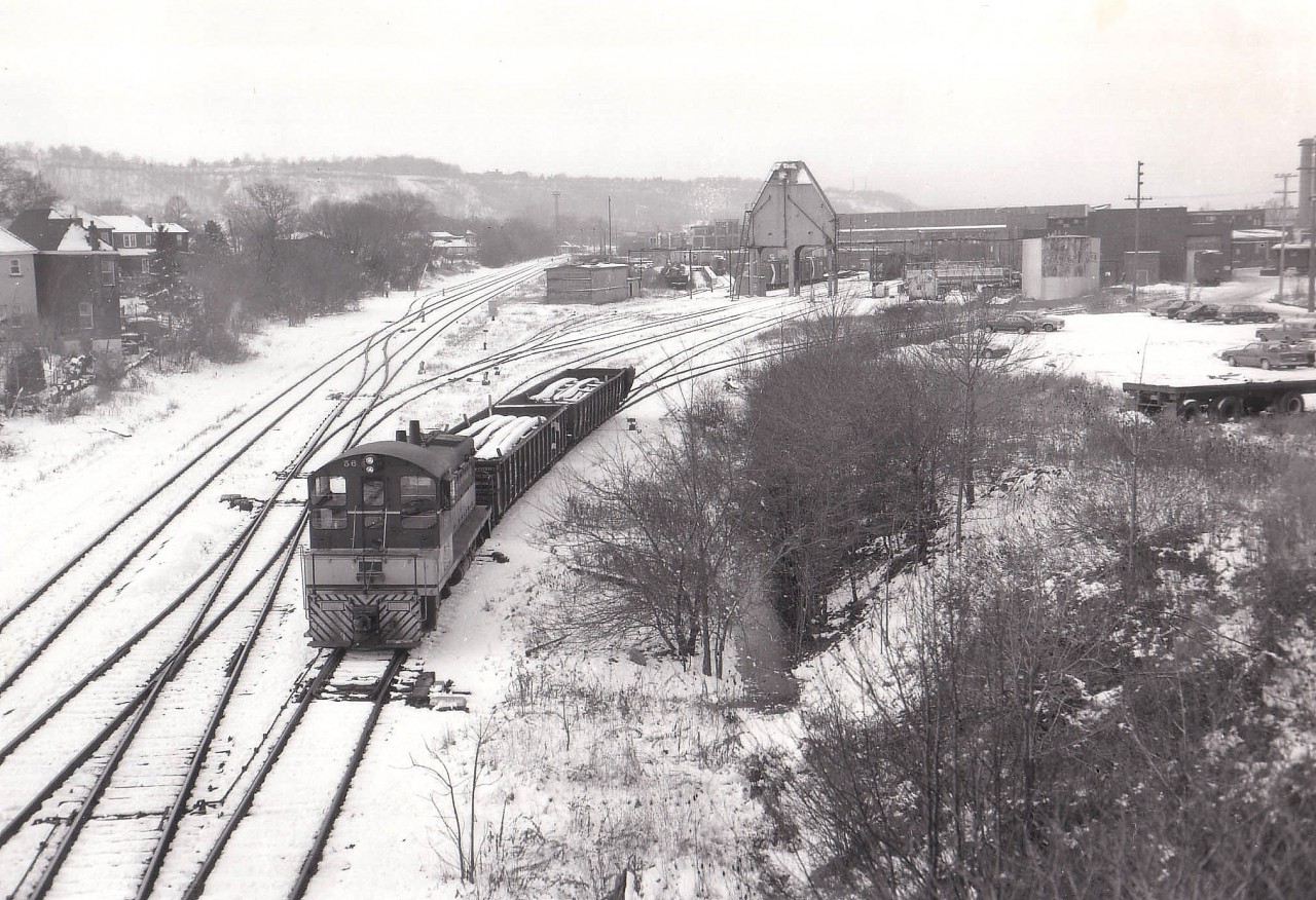 Cold day, few flurries in the air as I got out of the car on the Chatham St bridge to get a shot of the TH&B facilities as I knew the era of the beloved TH&B would be coming to a close. After all, the CP was taking over and that means old road was going to fall by the wayside. I was disappointed nothing was doing, save for #56 moving a couple gons around. The roundhouse (behind the fuel tank) and the old coaling tower would live but 5 more years and the yard would be cleared out. For many of us, this is a very nostalgic scene. James Adeney and Peter Newman are notably two members of this RP.ca group that spent time wandering and recording various scenes here back in the day. RIP, Chatham St. (Two tracks on the left are for the Aberdeen Yard, out of sight by a half mile,er..a Kilometer,  which still sees limited use.)