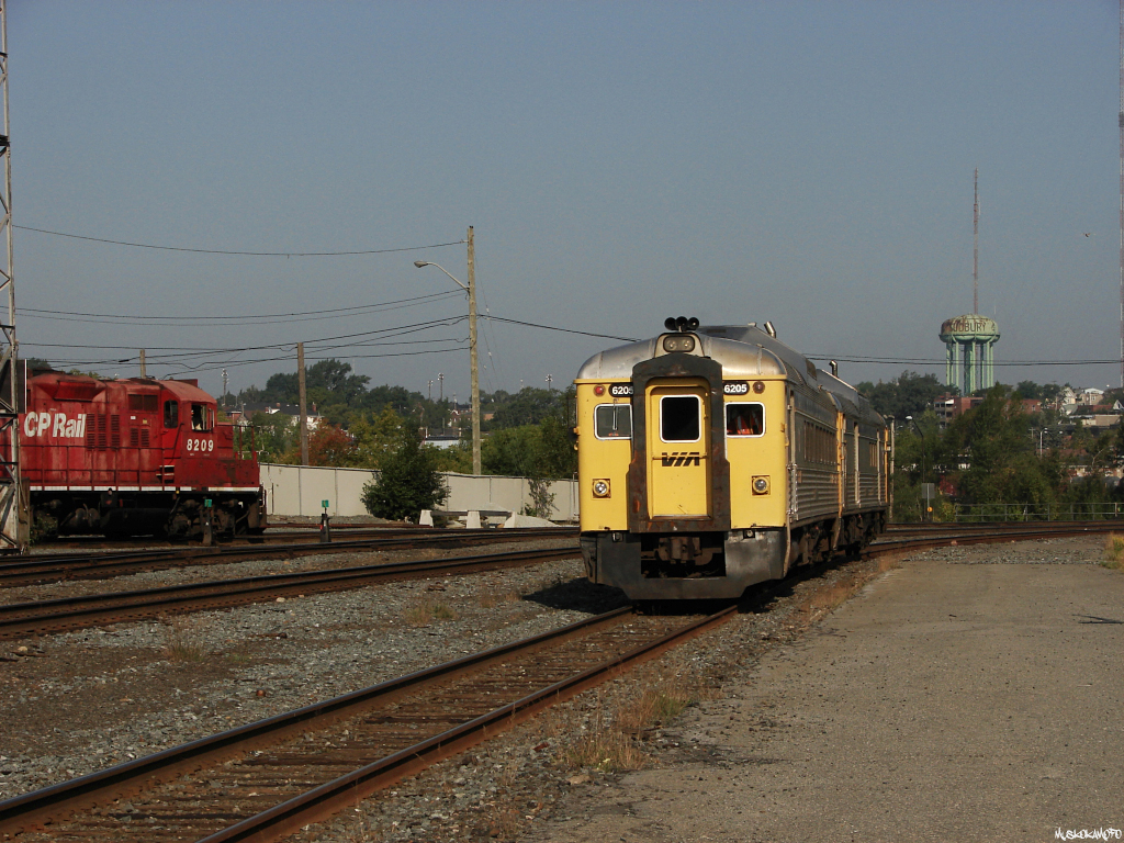 VIA 6250 West shoves up to the station platform on the North track to load up before 6250 and 6205 depart for White River with VIA 185, while CP 8209 bangs out a few tracks in the yard.