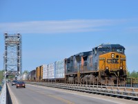 <b>Trains and cars sharing the bridge.</b> CN 327 with a pair of CSXT AC units (AC4400CW CSXT 5106 and SD70MAC CSXT 4817) crosses the Beauharnois canal on the Larocque Bridge which is used by both cars and CSXT (this is their Montreal subdivision). As can be seen in the distance this is a lift bridge, in fact both cars and CN 327 had been delayed by a boat just before.