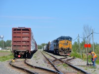 <b>Splitting CN 327 in two.</b> CN 327 has just finished splitting its train in two and putting it into the two sidings in Huntingdon on CSXT's Montreal sub as the train would not fit in the first siding. The conductor has just finished putting the derails back on and is lining the switch for the main. Soon a CSX crew will show up with CN 326 and take this train south. Power is a pair of CSXT AC units (AC4400CW CSXT 5106 and SD70MAC CSXT 4817).