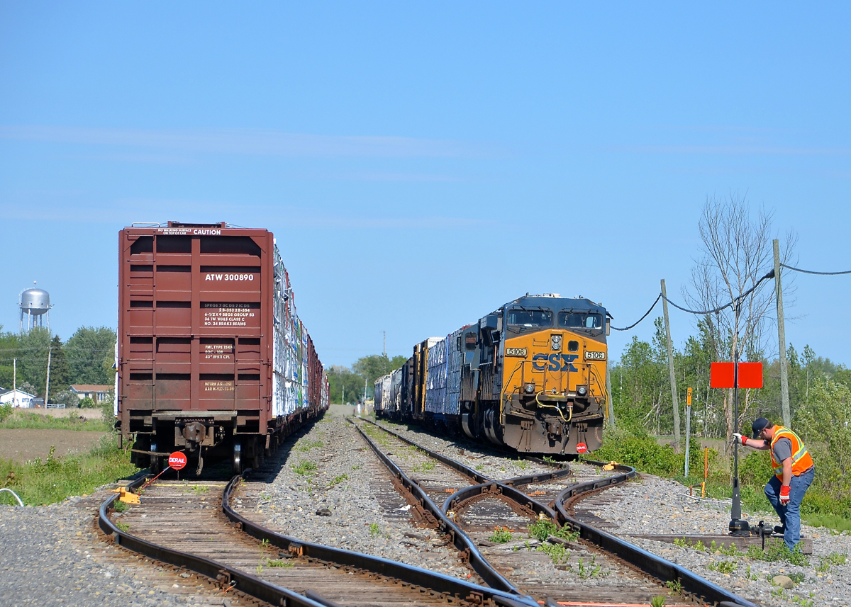 Splitting CN 327 in two. CN 327 has just finished splitting its train in two and putting it into the two sidings in Huntingdon on CSXT's Montreal sub as the train would not fit in the first siding. The conductor has just finished putting the derails back on and is lining the switch for the main. Soon a CSX crew will show up with CN 326 and take this train south. Power is a pair of CSXT AC units (AC4400CW CSXT 5106 and SD70MAC CSXT 4817).