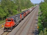 <b>Big and small EMD.</b> Two generations of EMD power (SD60 CN 5457 & GP9 CN 4129) lead CN 527 towards nearby Taschereau Yard on a very humid afternoon.