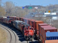 The Pointe St-Charles switcher heads west with a pair of GP9's (CN 7246 & CN 7015) with a cut of cars for Taschereau Yard as a very late CN 120 passes at right.