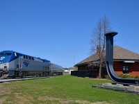 <b>Past the St-Jean station and the spike.</b> The southbound <i>Adirondack</i> is rounding the curve in front of the ex-Grand Trunk station in St-Jean-sur-Richelieu. At right is an oversized spike to commemorate how this was the terminus of Canada's first railway.