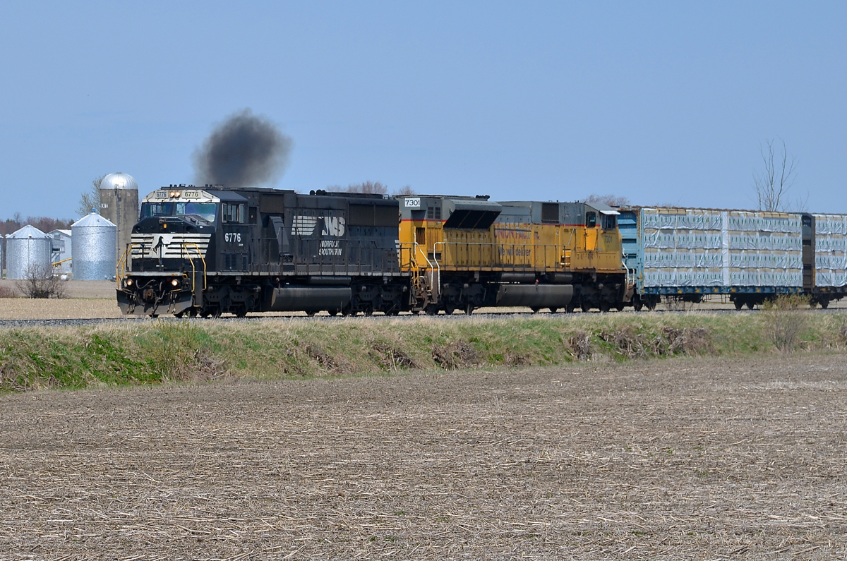 An ex-Conrail SD60M smoking it up. CN 528 is only a couple of miles from the U.S. border as it approaches Rouses Point, NY where it will become CP 930 and a CP crew will take over for the its journey south. The ex-Conrail leader (NS 6776) is smoking it up as the train accelerates. Trailing is ex-UP SD90 NS 7301