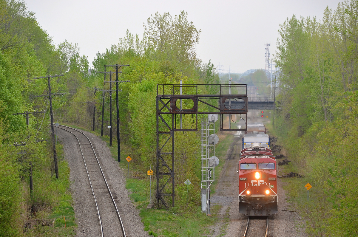 CP 9733 and an unknown ES44AC lead a pitifully short CP 253 through Montreal West on an overcast and muggy morning, its trip from Binghamton, NY almost complete. At left is North Junction which AMT commuter trains from the north shore use to get to downtown Montreal.