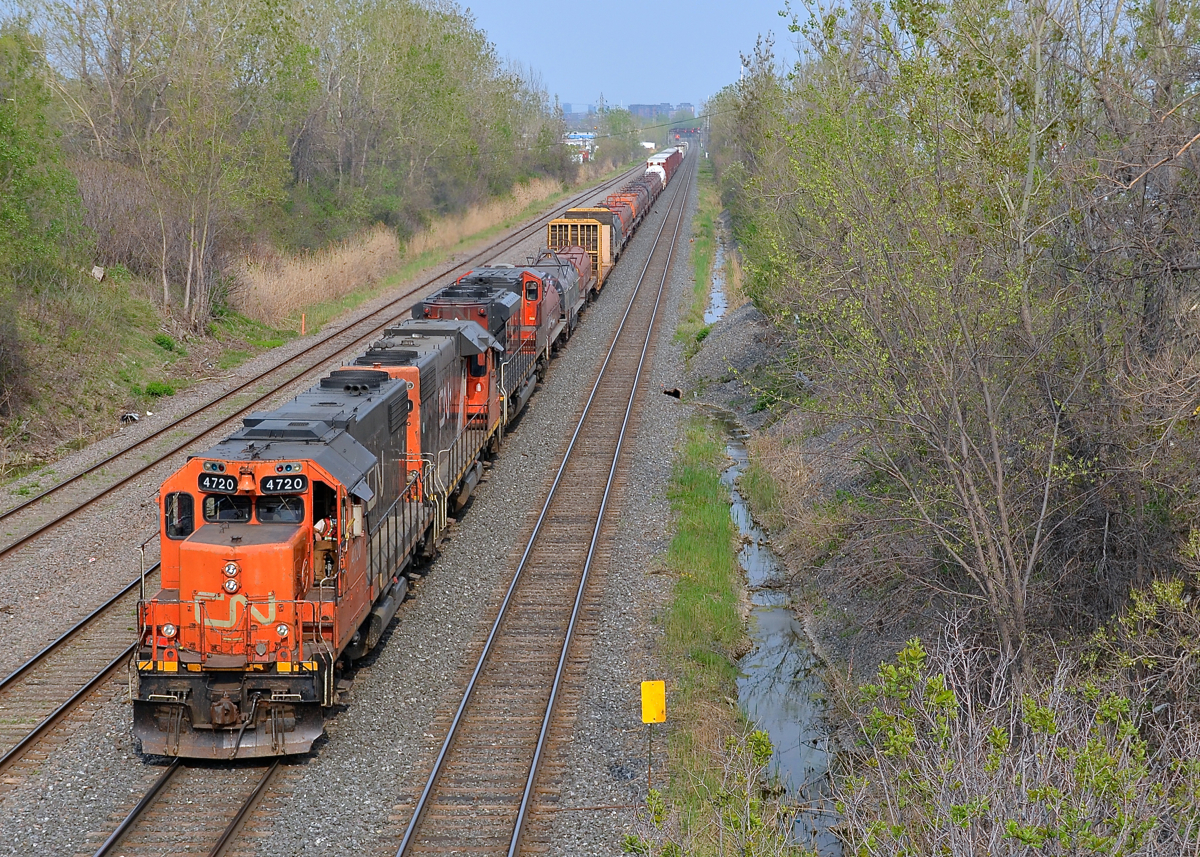 A pair of GP38-2's and an SD70M-2 (CN 4720, CN 4729 & CN 8815) lead CN 527 towards nearby Taschereau Yard. At the head end are quite a large cut of coil steel cars.