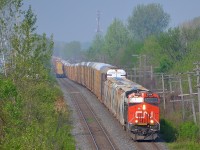 CN 372 heads east through Pointe-Claire after passing CN 149. This train is mostly autoracks and has CN 2334 headend and CN 2301 mid-train.