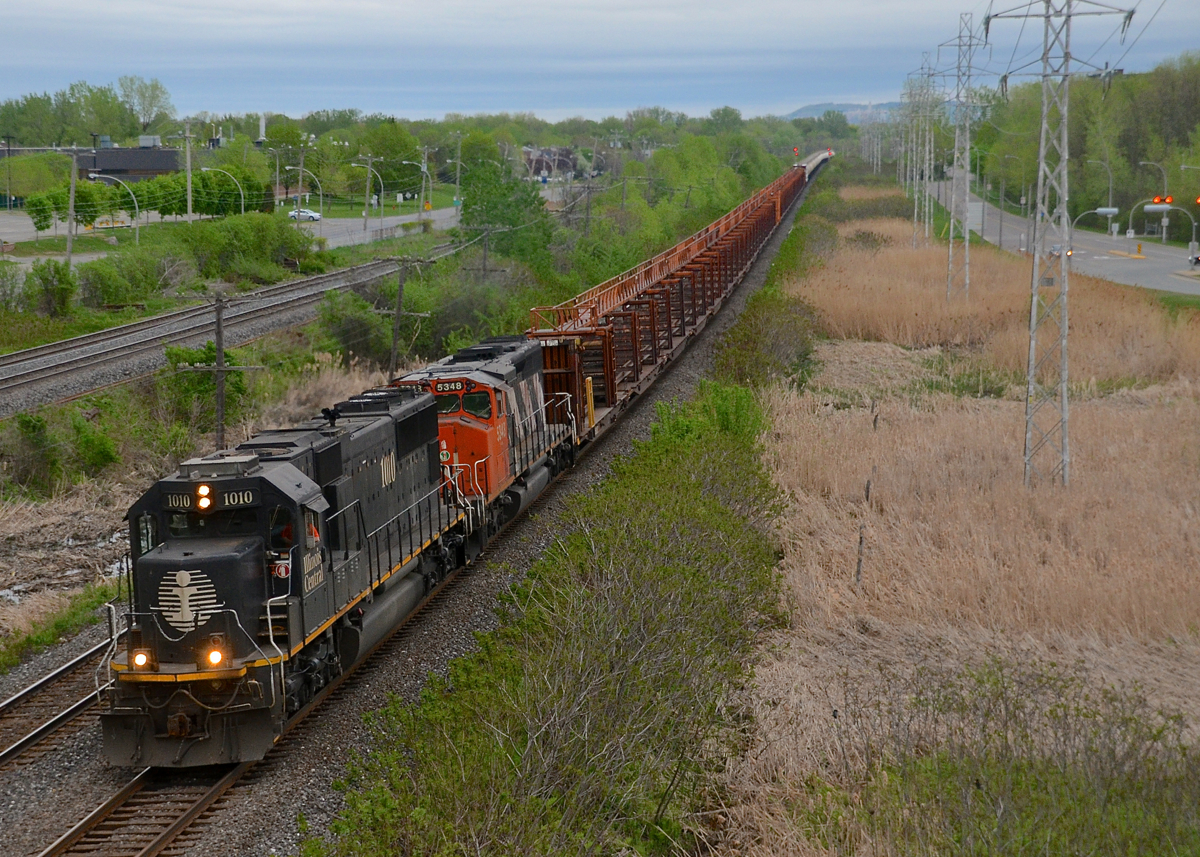 IC 1010 & CN 5348 lead CN 482 which has empty rail cars, a loaded centrebeam and then 34 TankTrain loads for Maitland, ON.