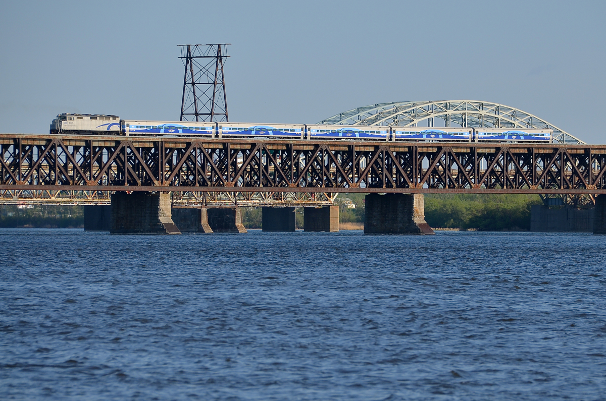 Last train of the day for Candiac. AMT 1342 has 5 Bombardier cars in tow as it heads towards Montreal's South shore with AMT 95, the last train of the day for Candiac. It is crossing over the St-Lawrence river on CP's double track St-Lawrence bridge. Behind it is the Mercier bridge.