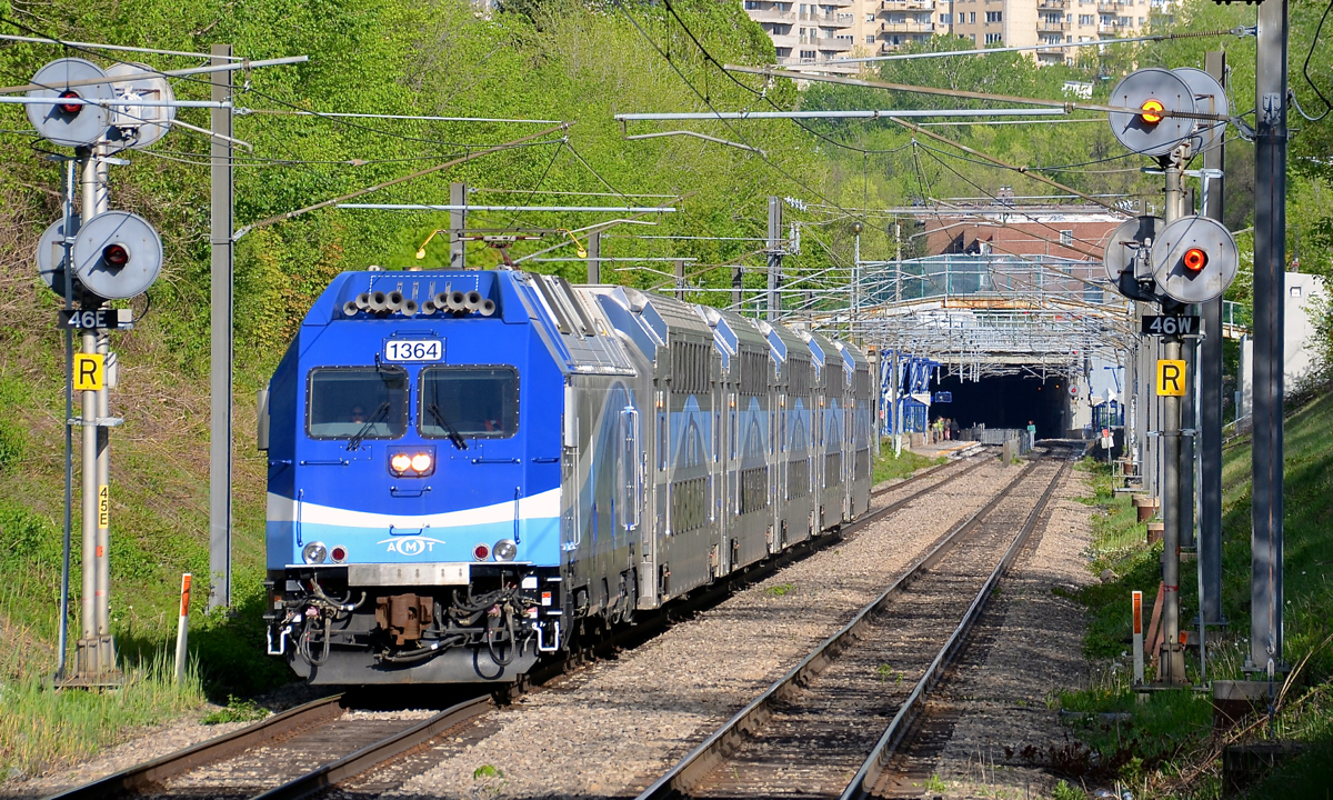 In electric mode, finally! Until the opening of the Mascouche line last December, AMT's fleet of dual-mode ALP-45DP's had operated 100% in diesel mode. With the opening of the Mascouche line, some of them are finally being used in electric mode (through the Mount Royal tunnel) followed by diesel mode for most of their run. Here AMT 1209 for Mascouche has just left Canora Station and is approaching Mount Royal Station with its engine (AMT 1364) having its pantograph up. The north end of the tunnel is visible in the distance.