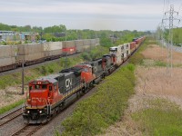 <b>Three intermodal trains.</b> CN 149 heads west through Pointe Claire with CN 2102, CN 5763 & IC 2712 on the south track of CN's Kingston sub. The tail end of CN 106 is on the north track and CP 112 is inbound at left on CP's Vaudreuil sub.