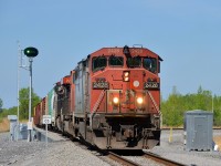 <b>Passing a switch point indicator.</b> CN 327 is passing a switch point indicator that I believe indicates over the radio whether the switch is lined for the main or the diverging route. CN 327 has CN 2428, CN 5643, CN 2230 for power and he is heading south after having to wait for the nearby Larocque bridge to lower after opening for a boat on the Beauharnois canal. He is heading to Huntingdon, Qc where a CSXT crew will take this train to Massena, NY and the CN crew will bring CN 326 to Montreal.