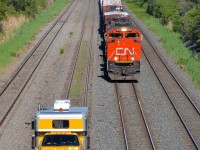 CN 527 and a Sperry truck (SRS 945) are both westbound on the Montreal sub near Taschereau yard. CN 527 has an all-GMD lashup of CN 8004, CN 4771 & CN 7502 (a hump unit returning from CAD).