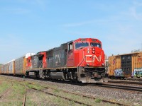 On the hottest day of the year so far, CN 5794 and 2026 lead an eastbound through the yard. They are passing a line of box cars that have suffered from illicit art!