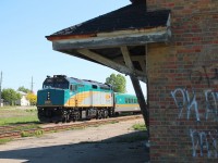 Westbound Via framed by the abandoned station.