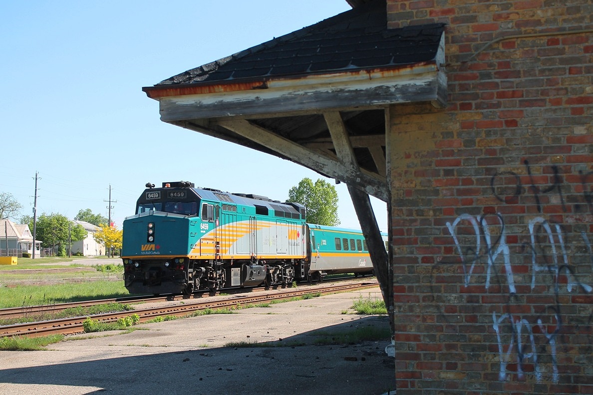 Westbound Via framed by the abandoned station.