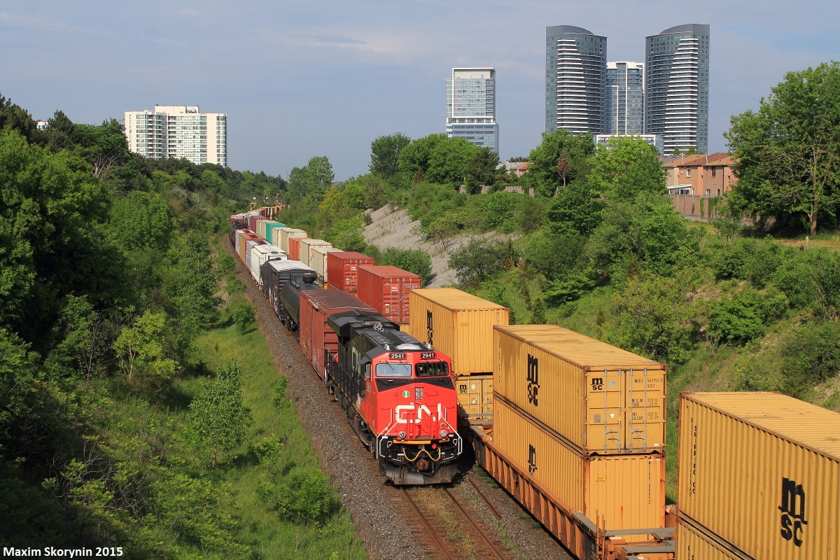A solo shiny General Electric product is on point of a westbound manifest with some more help from a DP unit mid train. The train on the south track is eastbound intermodal train Q14891 and is a high priority intermodal which runs daily between Chicago and Montreal. It was stationary at the time with its head end just short of Doncaster Junction which is about 3 miles down the track, likely due to either a GO Transit commuter train occupying the diamond or M36921 being on the south track and needing to diverge.